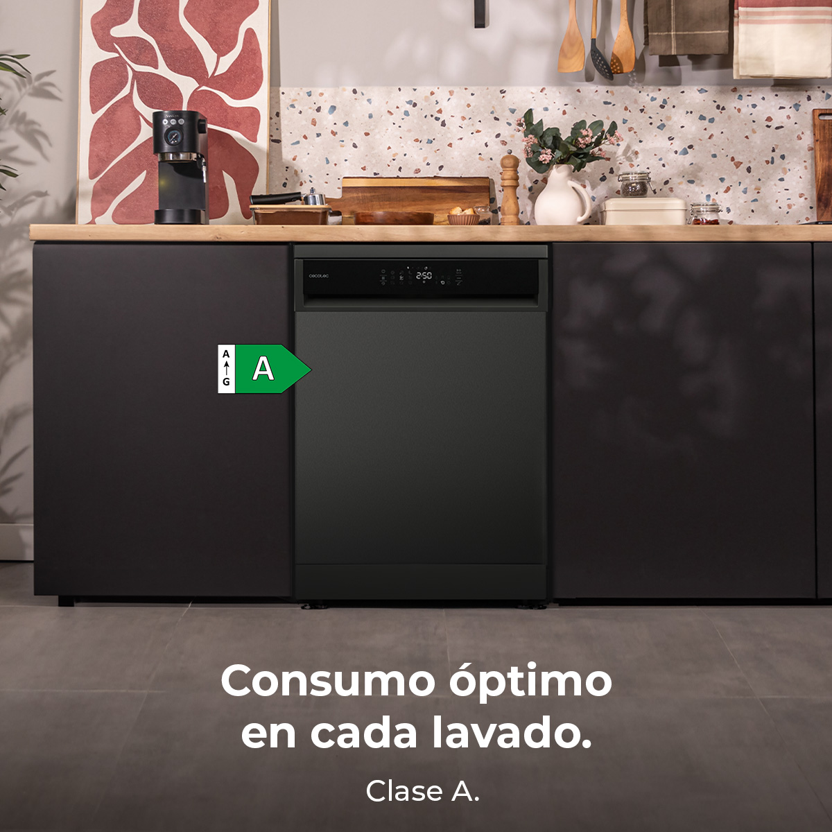 Una lavastoviglie verde scuro in una cucina. Sopra, un bancone di legno con una macchina per il caffè e altri oggetti.