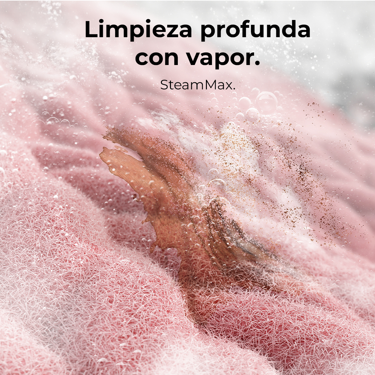 Zbliżenie różowej tkaniny z brązową plamą w trakcie czyszczenia. Pojawiają się pęcherzyki i para. Tekst: 'Limpieza profunda con vapor. SteamMax.'