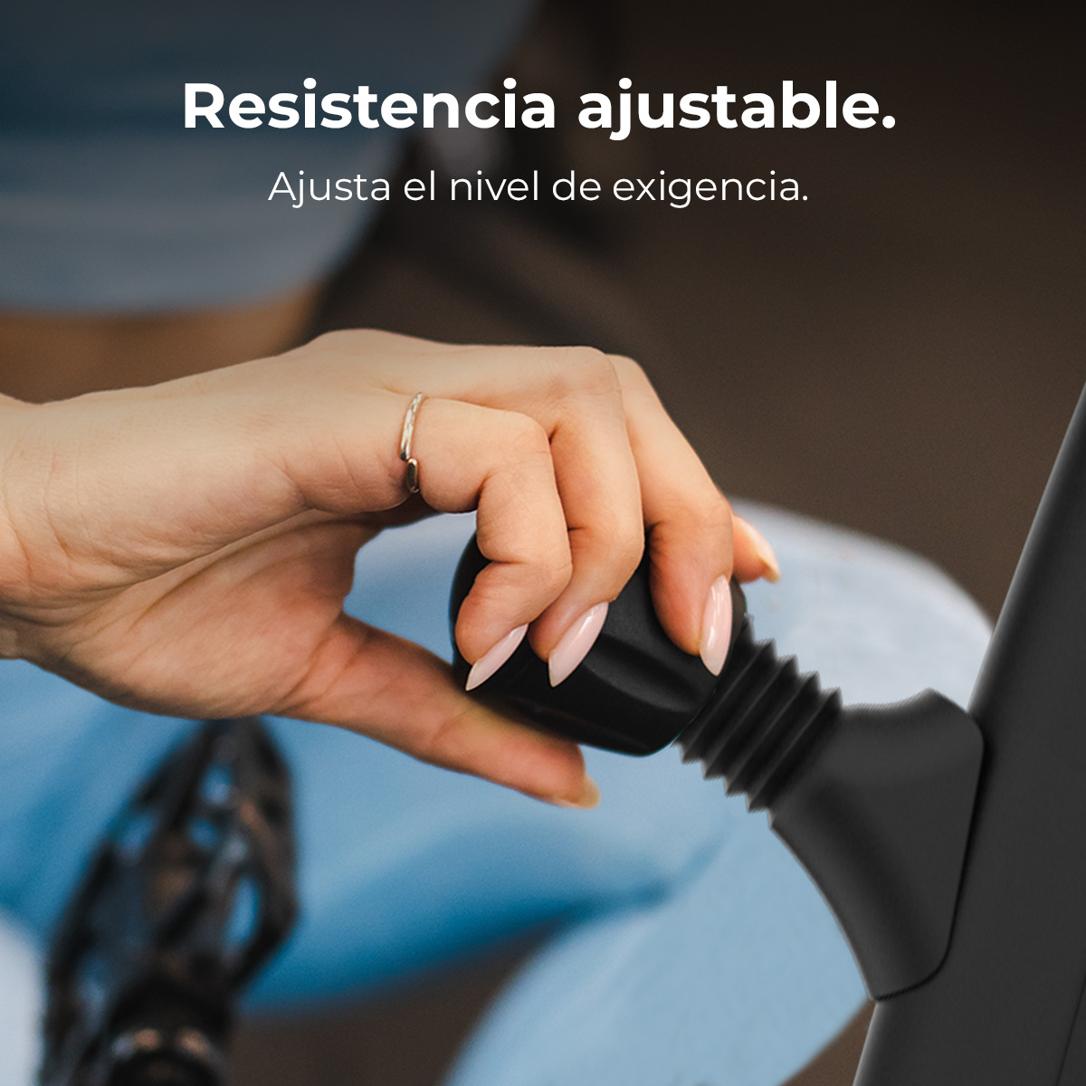 Una mano ajusta una perilla negra. Se muestra la mano de una mujer con un anillo y uñas rosas. El fondo está borroso con texto.