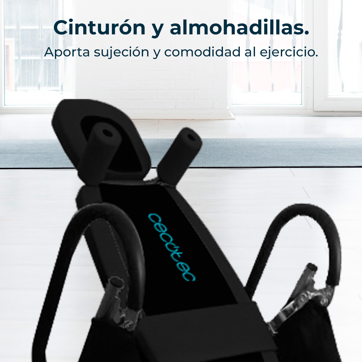 Czarny stół inwersyjny z niebieskim logo znajduje się w pokoju. Ma podłokietniki i zagłówek. Tło: okna i jasnoszara mata.