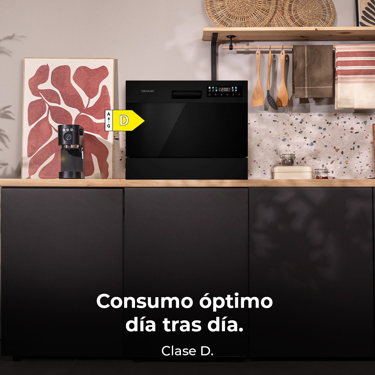 Un lavavajillas negro con etiqueta de eficiencia energética (D) está sobre una encimera de madera. Arriba, una estantería con utensilios y decoración.