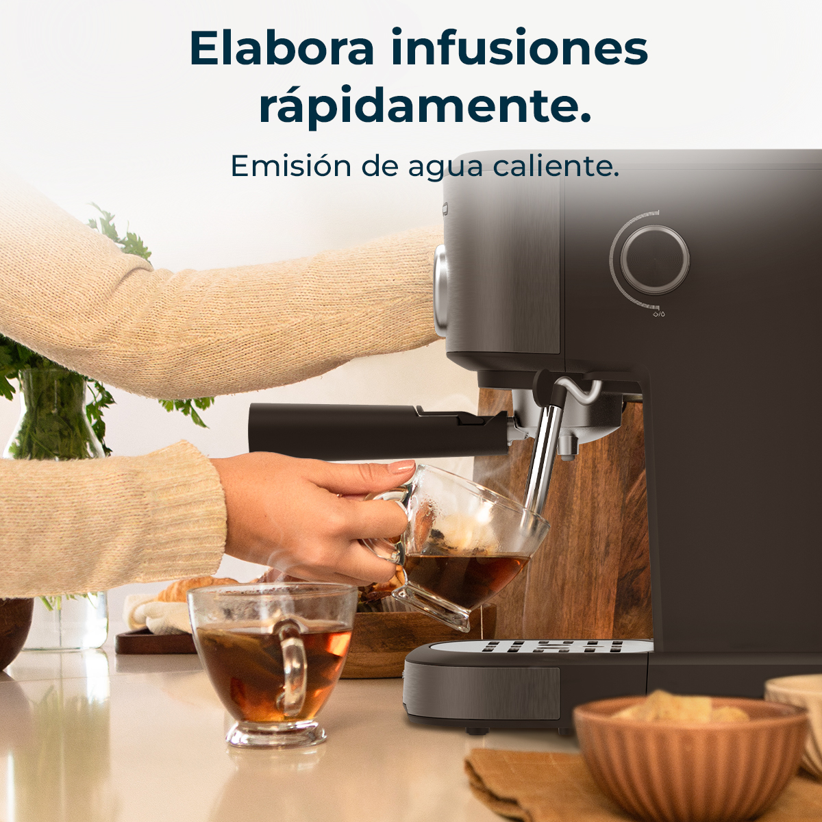 Una persona sta versando il tè da una macchina da caffè in una tazza di vetro. La tazza è piena di tè, ne esce vapore.
