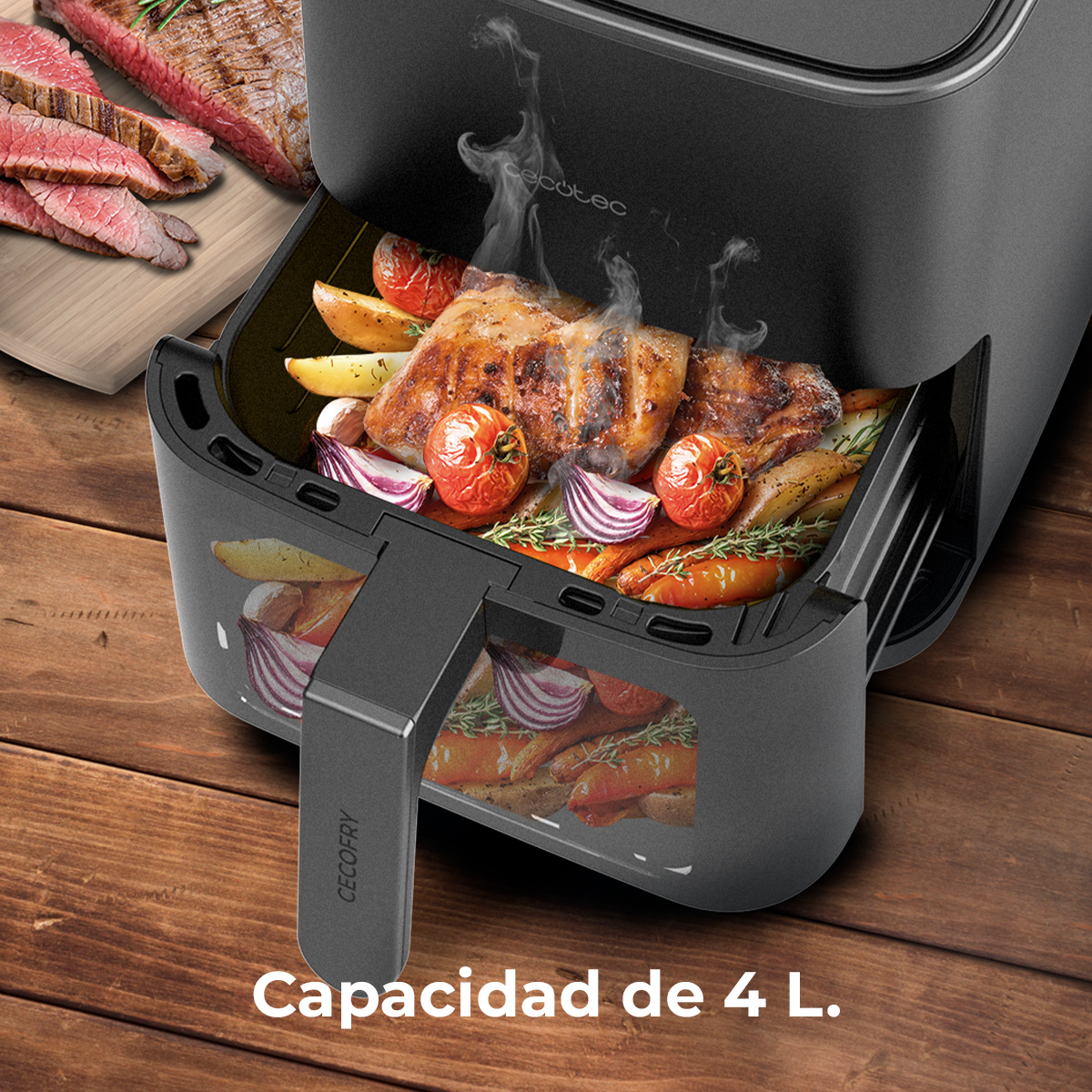 Frytownica powietrzna z ugotowanym jedzeniem w środku, w tym mięsem, pomidorami i warzywami. Pokrojony stek jest widoczny na drewnianej desce.