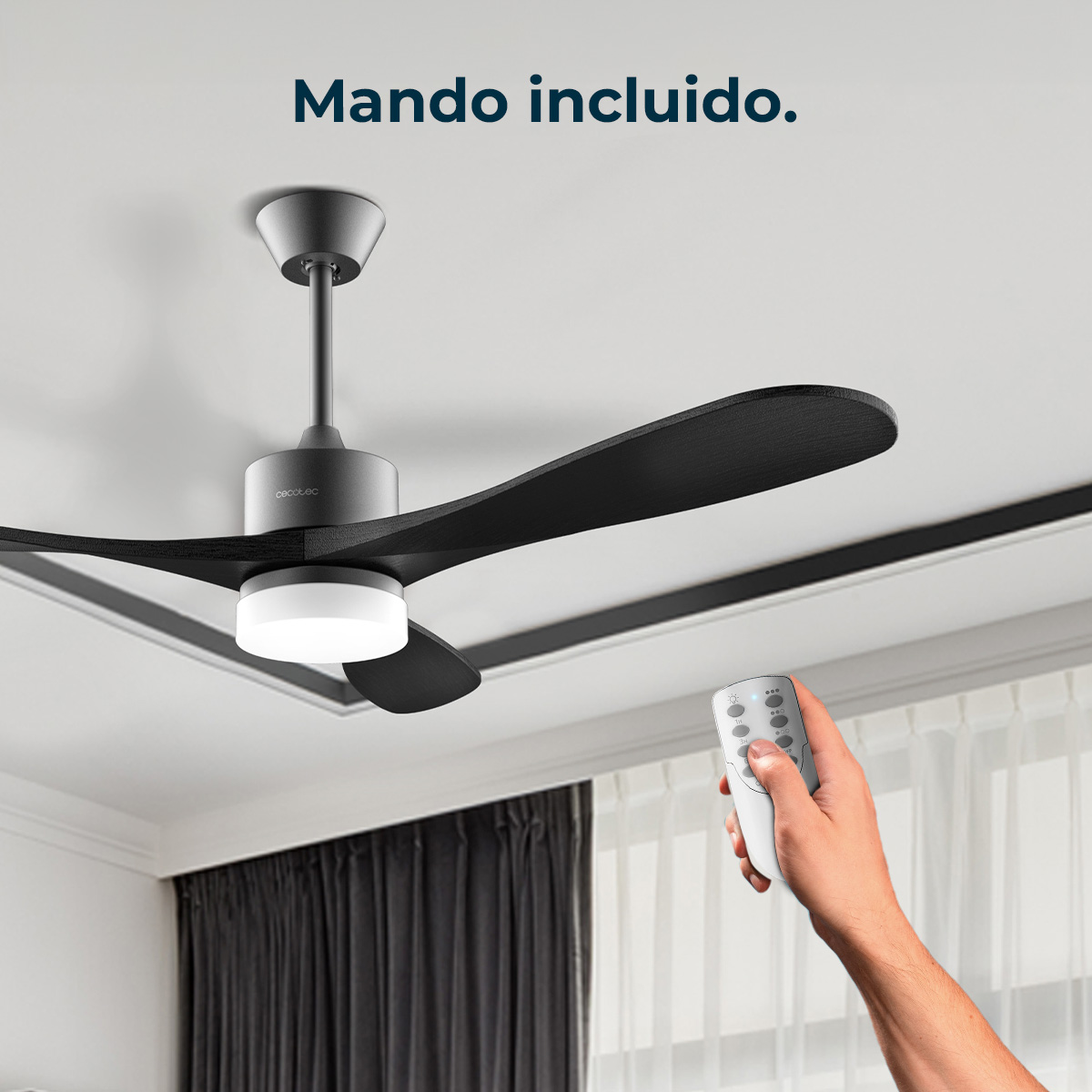 Un ventilatore a soffitto nero con telecomando in mano. Il ventilatore ha pale nere e una luce. Il telecomando ha dei pulsanti.