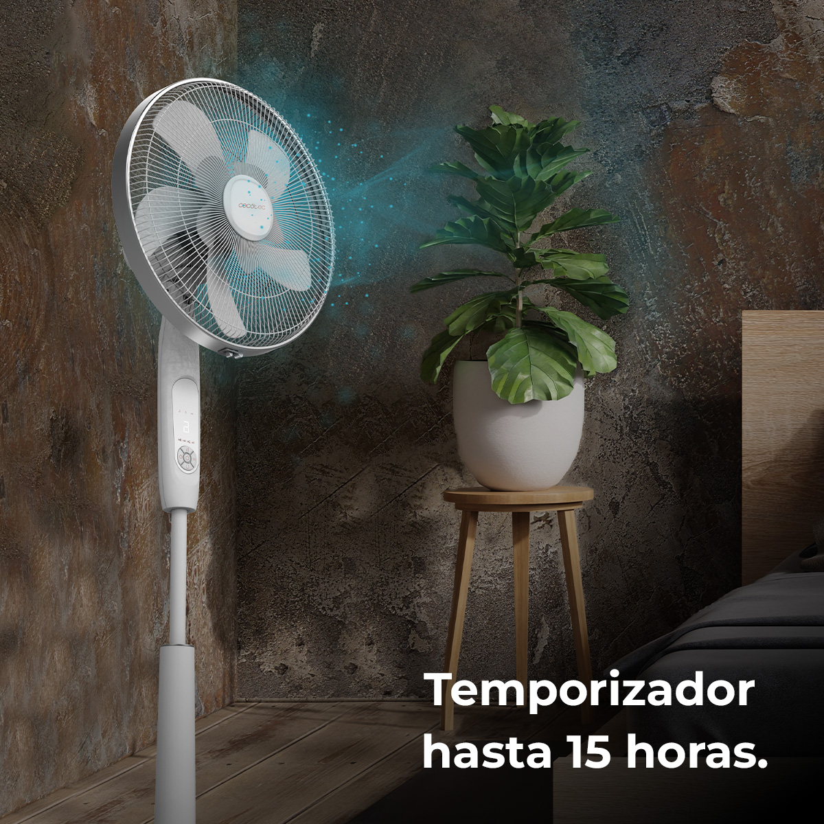 Biały wentylator rozpyla mgłę w kierunku rośliny w białej donicy na drewnianym stołku. W tle łóżko.