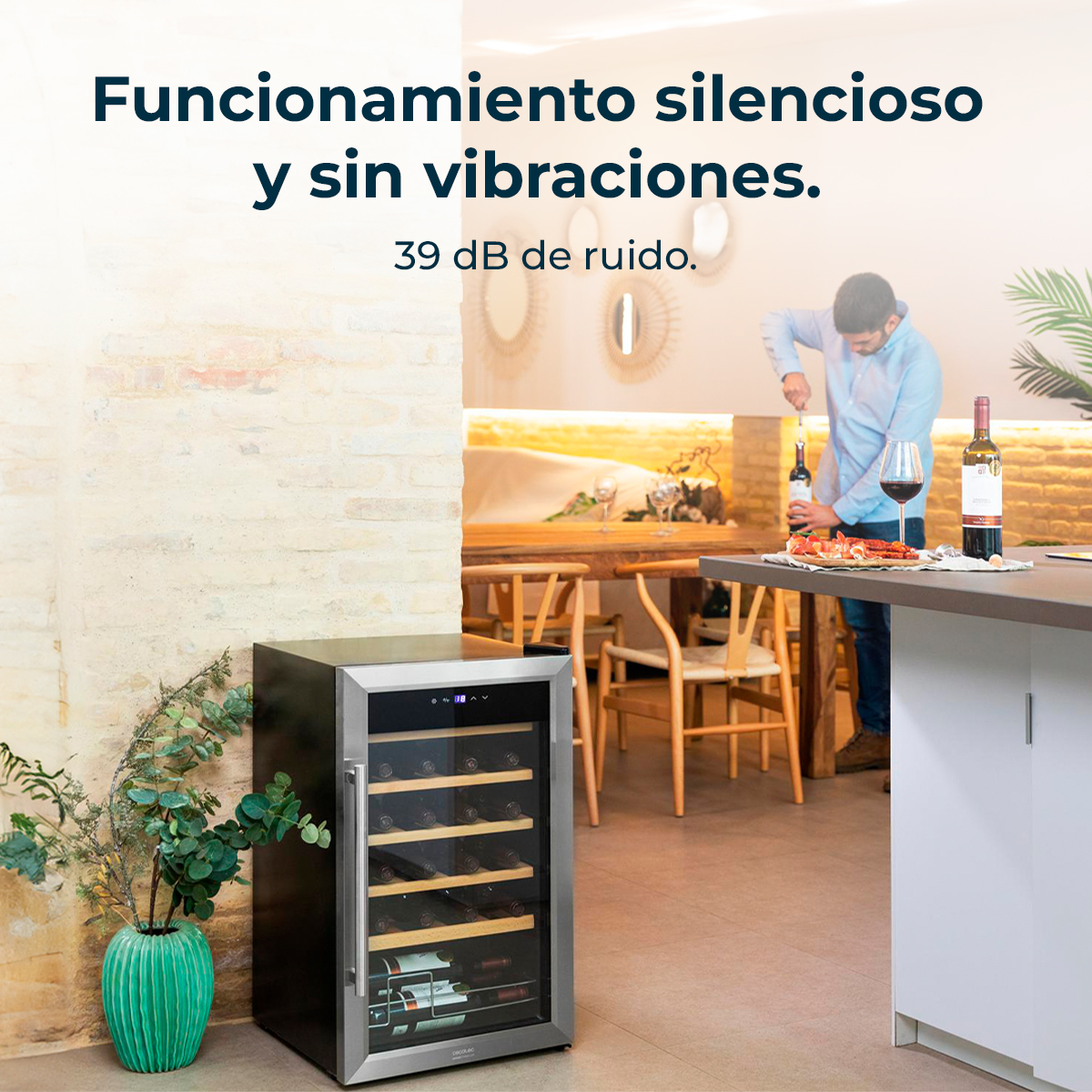 Mężczyzna otwiera wino. Chłodziarka do wina jest na pierwszym planie. Stół jest nakryty winem i jedzeniem. Pokój ma nowoczesny design.