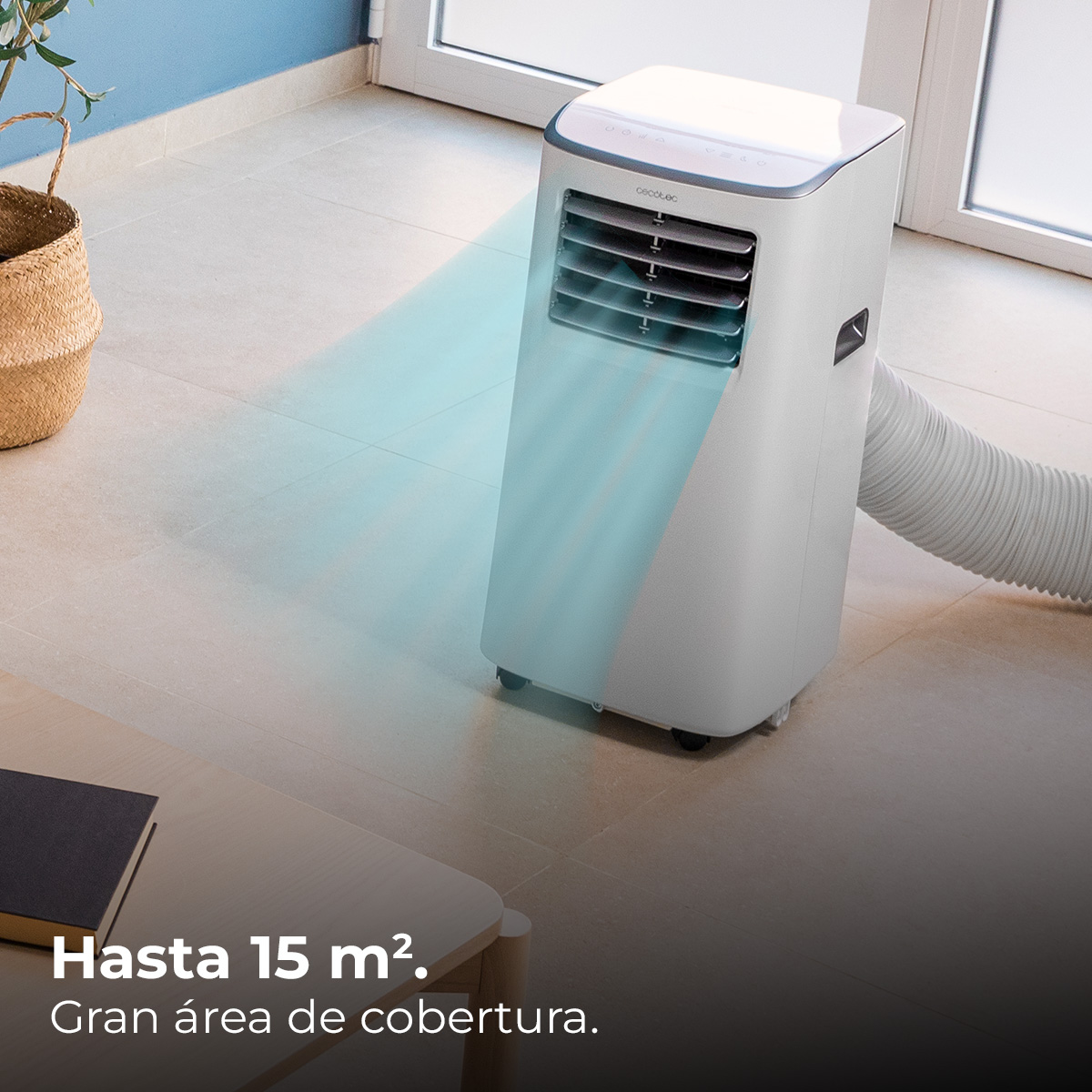 Biały klimatyzator emitujący chłodne powietrze. Wiklinowy kosz i stół z książką w tle.