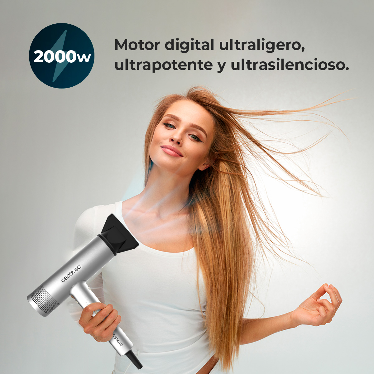 Una donna tiene in mano un asciugacapelli argentato. I suoi lunghi capelli biondi volano. Testo: Motor digital ultraligero, ultrarpotente y ultrasilencioso.