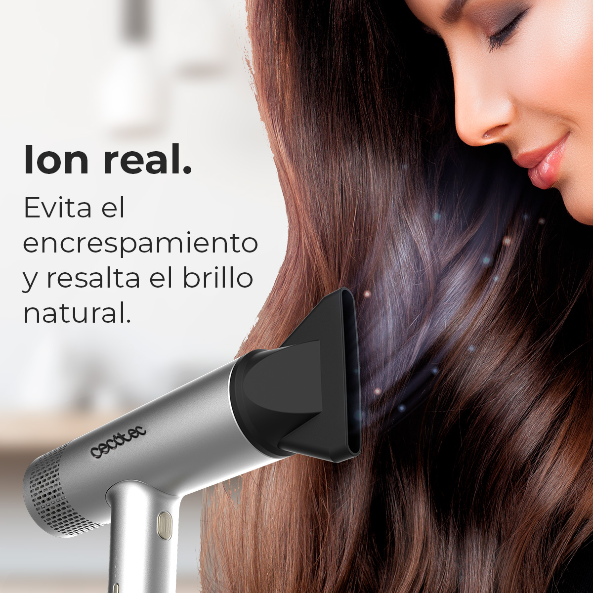 Una donna sorride mentre un asciugacapelli argentato è diretto verso i suoi capelli. Il testo a sinistra promuove lucentezza e controllo dell'effetto crespo.