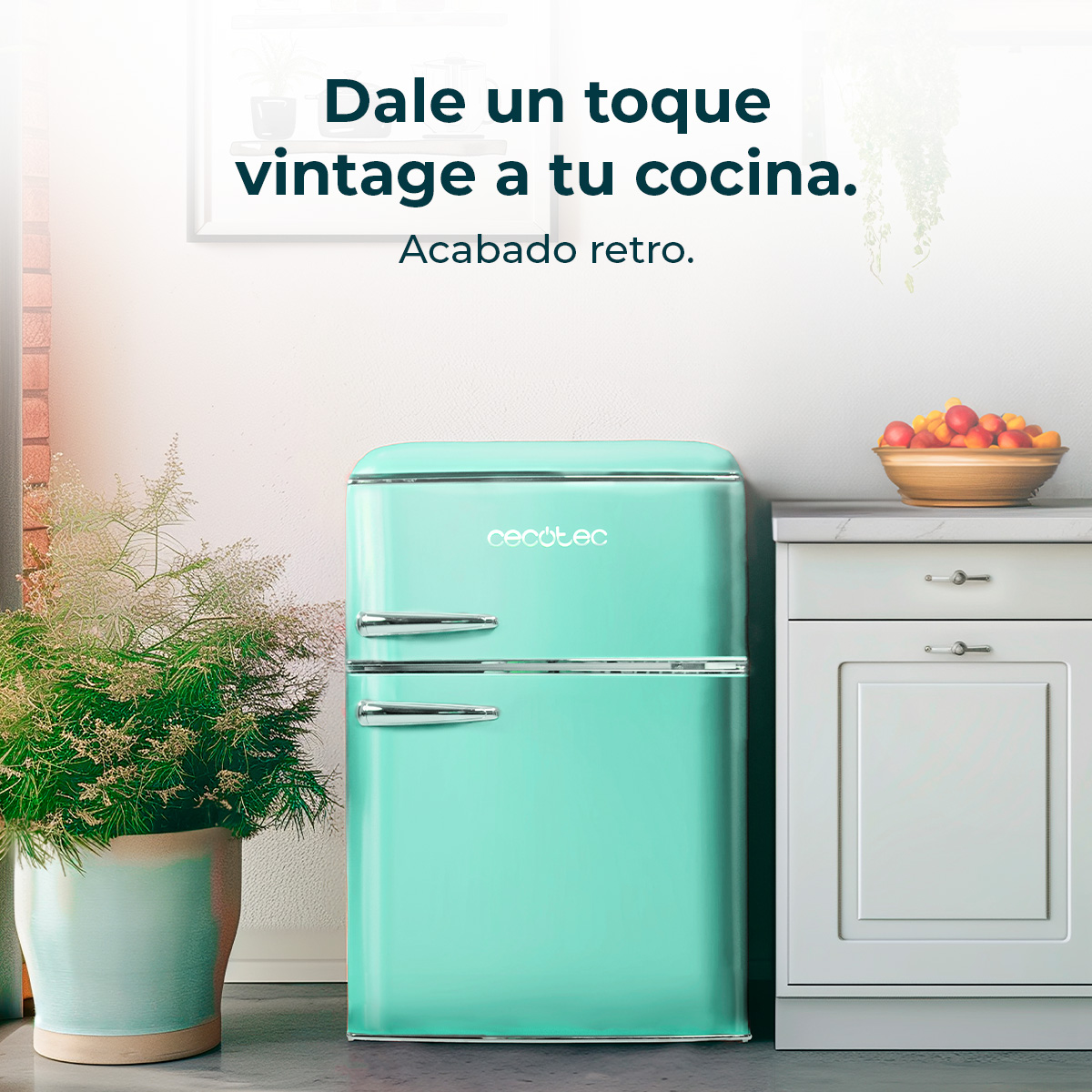 Miętowa lodówka w stylu retro stoi między rośliną a białą szafką z misą owoców na górze. Tekst: 'vintage'.