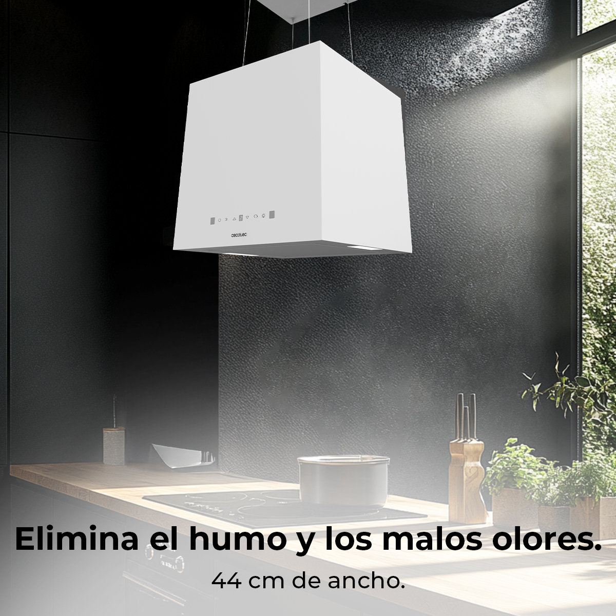 Campana extractora blanca sobre una estufa. La cocina es negra con una encimera de madera. Hay una ventana con plantas detrás.