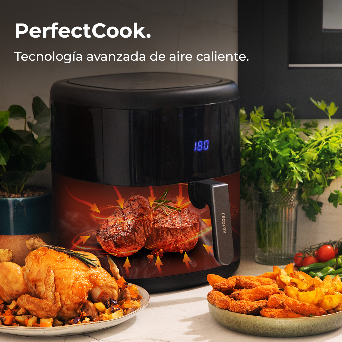 Een airfryer met gekookte kip en steaks. Groenten op tafel. Het display toont 180. Het merk is PerfectCook.