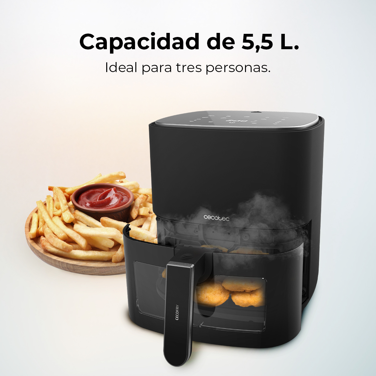 Freidora de aire negra con asa, papas fritas y ketchup. El texto dice: Capacidad de 5,5 L, ideal para tres personas.
