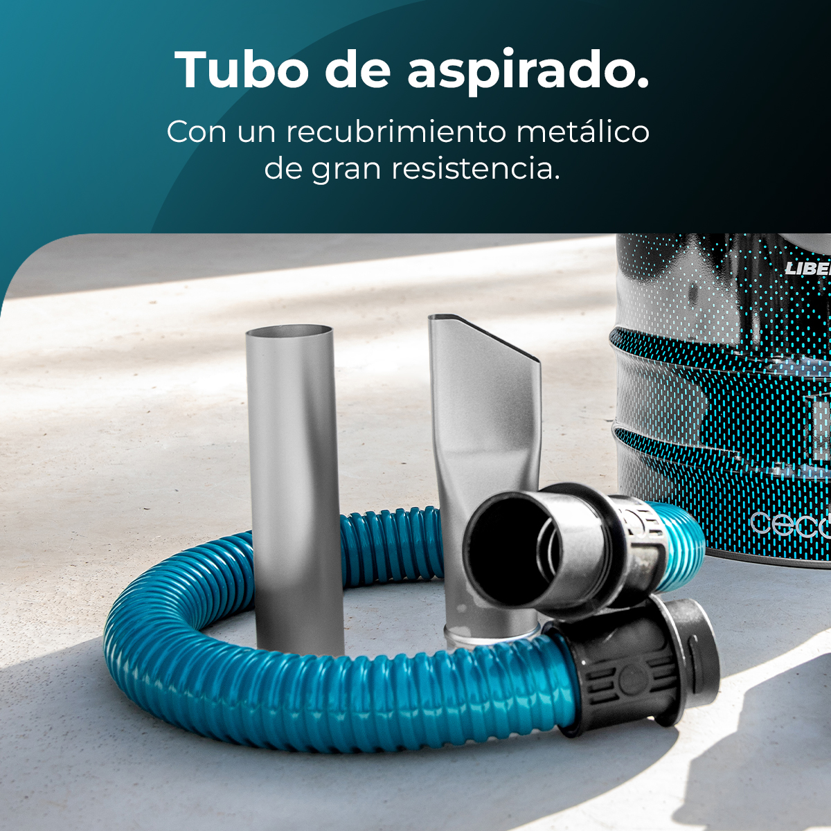 Piezas de aspiradora: una manguera corrugada azul, tubos plateados y conectores negros sobre una superficie de hormigón. Un bote al fondo.