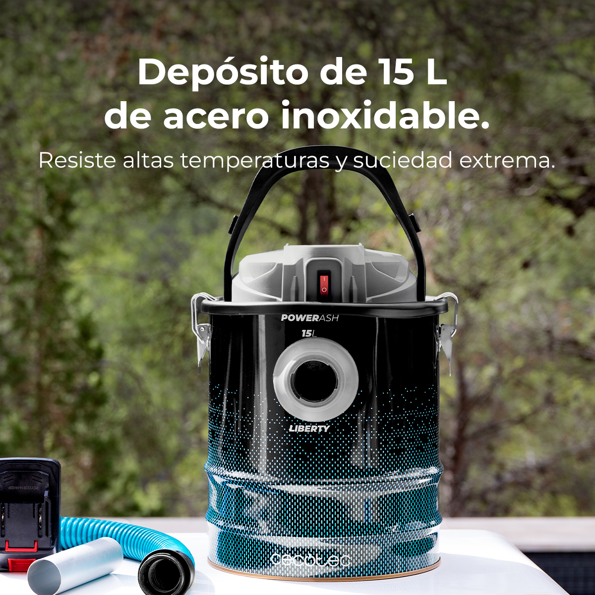 Una aspiradora de cenizas negra y azul con el texto 'POWERASH 15L LIBERTY'. Accesorios cerca y árboles de fondo.