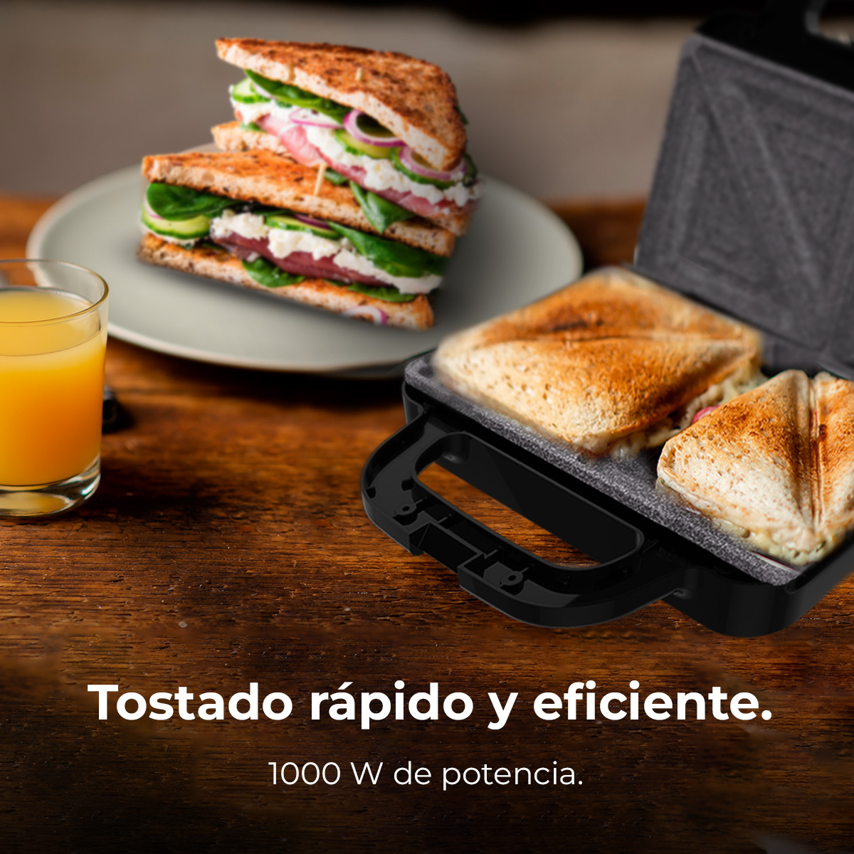 Una sandwichera con sándwiches tostados, un plato con sándwiches y un vaso de zumo de naranja sobre una mesa de madera.