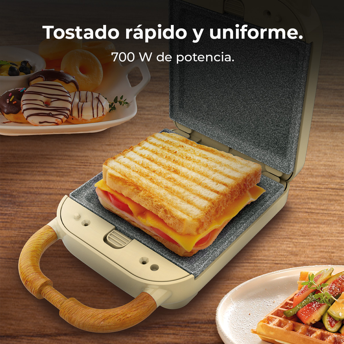 Una sandwichera con un sándwich a la parrilla dentro. Donas en el fondo. Gofres y frutas en un plato a un lado.