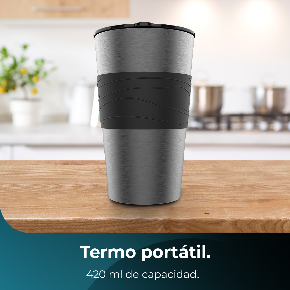 Metalowy kubek podróżny z czarną pokrywką i uchwytem na drewnianej powierzchni. Rozmyte tło kuchni.