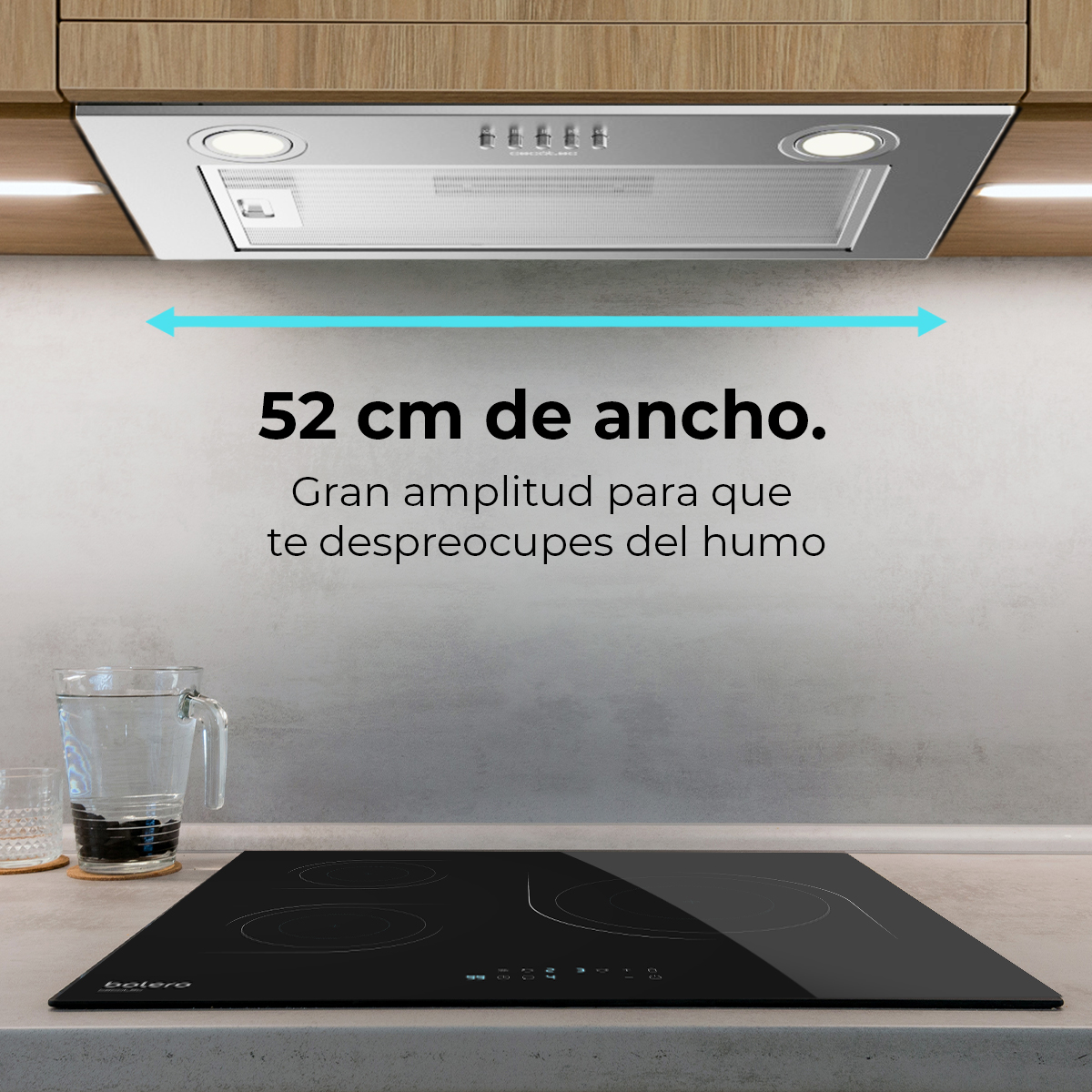 Scena cucina con piano cottura nero, bicchiere d'acqua e cappa. Il testo indica una larghezza di 52 cm.