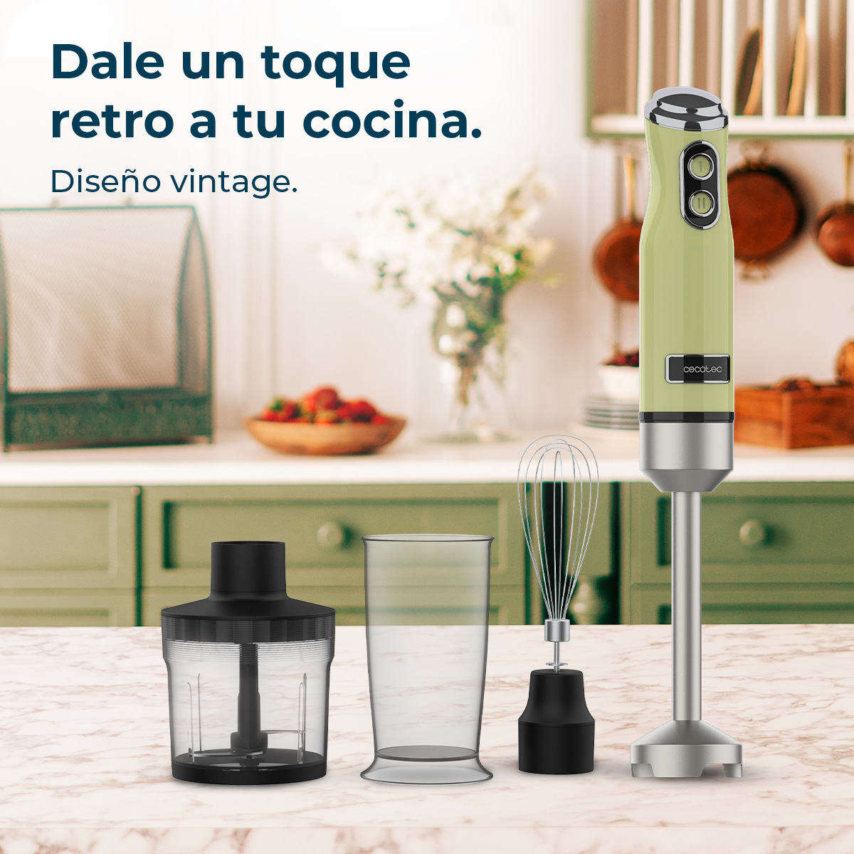 Una batidora de inmersión verde y plateada, accesorios para mezclar y una taza transparente sobre una encimera de mármol.