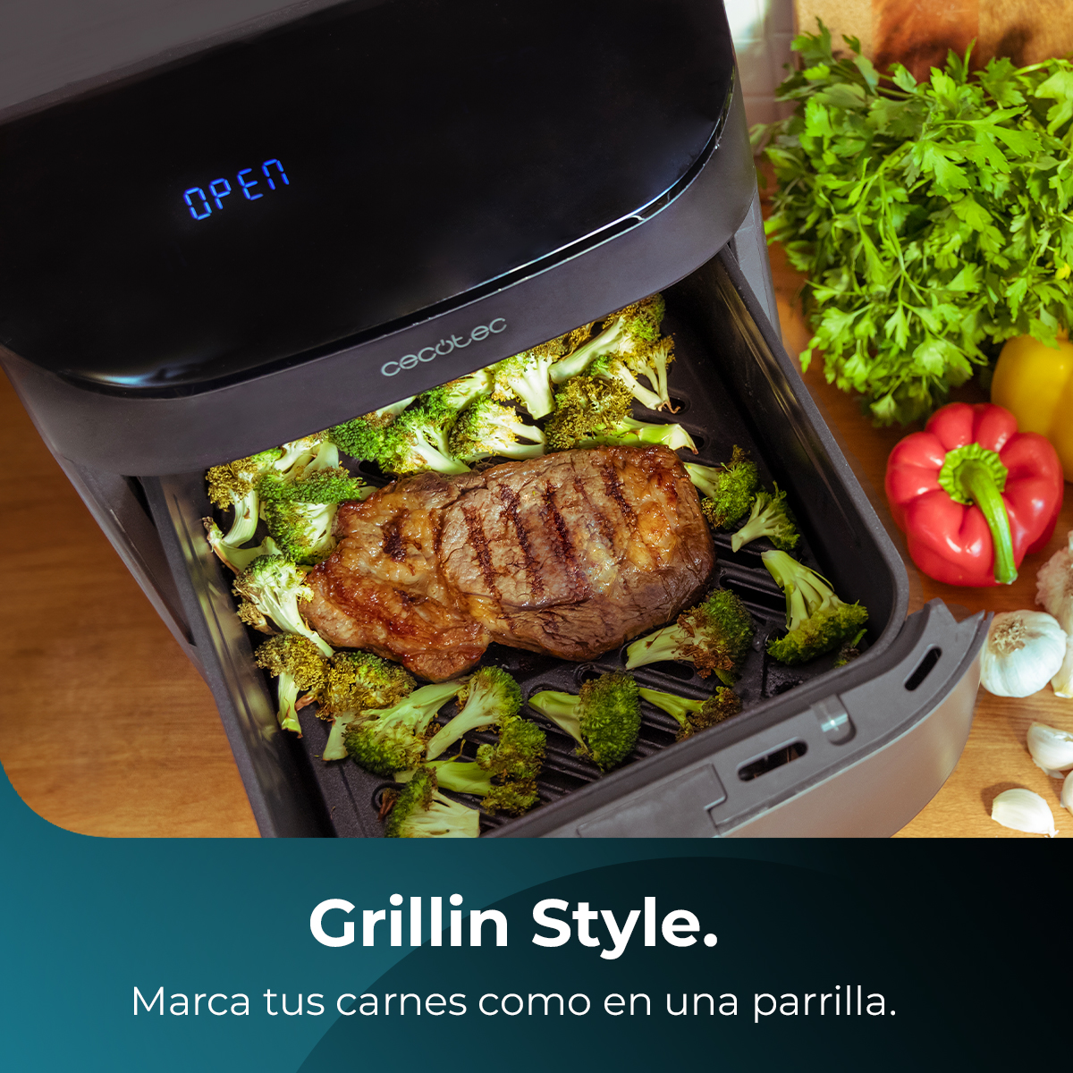 Grillowany stek i brokuły w frytkownicy Cecotec. Warzywa i inne składniki w tle, w tym czerwona papryka.