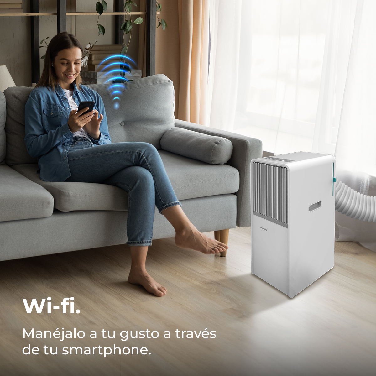 Donna sul divano con smartphone, simbolo Wi-Fi. Condizionatore bianco. Testo: 'Gestisci tramite smartphone'.