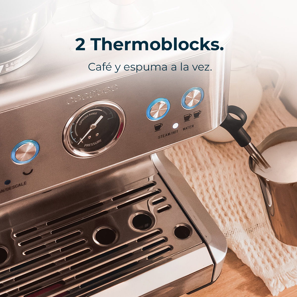 Zbliżenie ekspresu do kawy ze wskaźnikiem ciśnienia i przyciskami. Spieniacz do mleka jest w metalowym dzbanku.