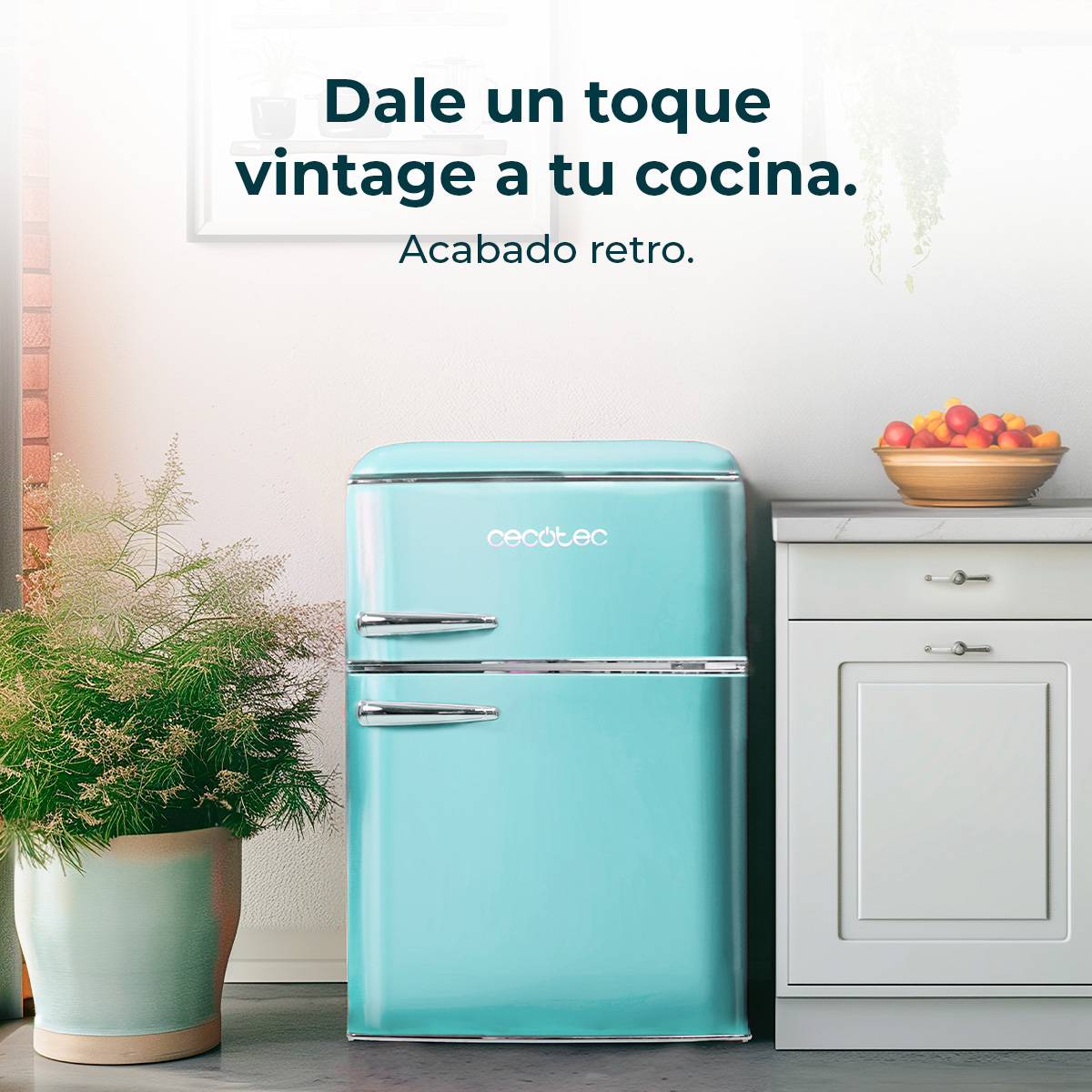 Turkusowa lodówka retro stoi w kuchni. Roślina w doniczce po lewej, a po prawej szafka z owocami.