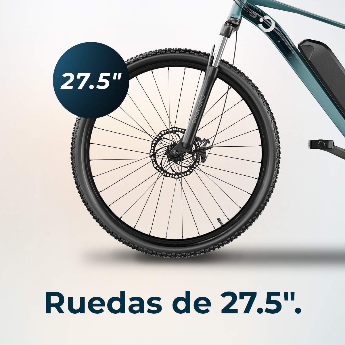Primo piano di una ruota di bicicletta con etichetta 27,5". La ruota è nera, con freno a disco. La bici è verde acqua.