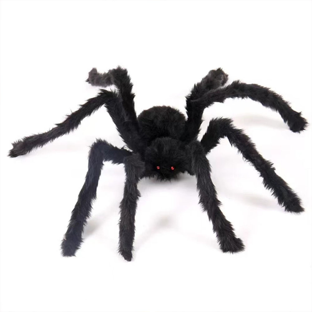 Eine große, schwarze, pelzige Spinne mit roten Augen sitzt auf weißem Grund. Ihre Beine sind ausgebreitet, und es scheint eine Halloween-Dekoration zu sein.