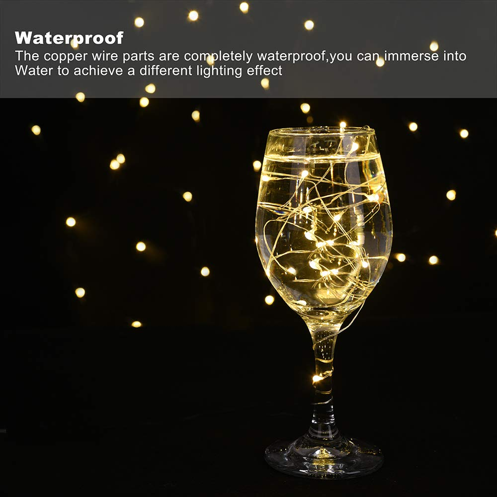 Ein Weinglas mit Wasser und leuchtenden Lichterketten. Der Hintergrund hat verschwommene gelbe Lichter auf schwarzem Grund.
