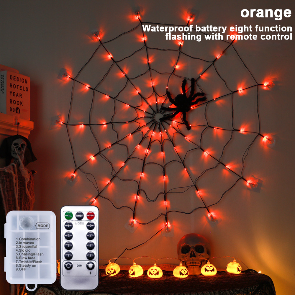 Halloween-Dekoration mit einem Spinnennetz aus Lichtern, einer Fernbedienung, Kürbislichtern und einem Totenkopf.