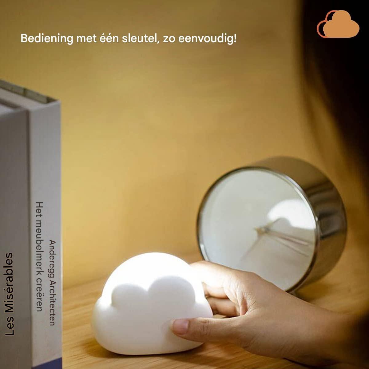 Eine Hand berührt eine weiße wolkenförmige Lampe. Auf dem Tisch liegen ein Buch und eine metallische Uhr. Text auf Niederländisch.