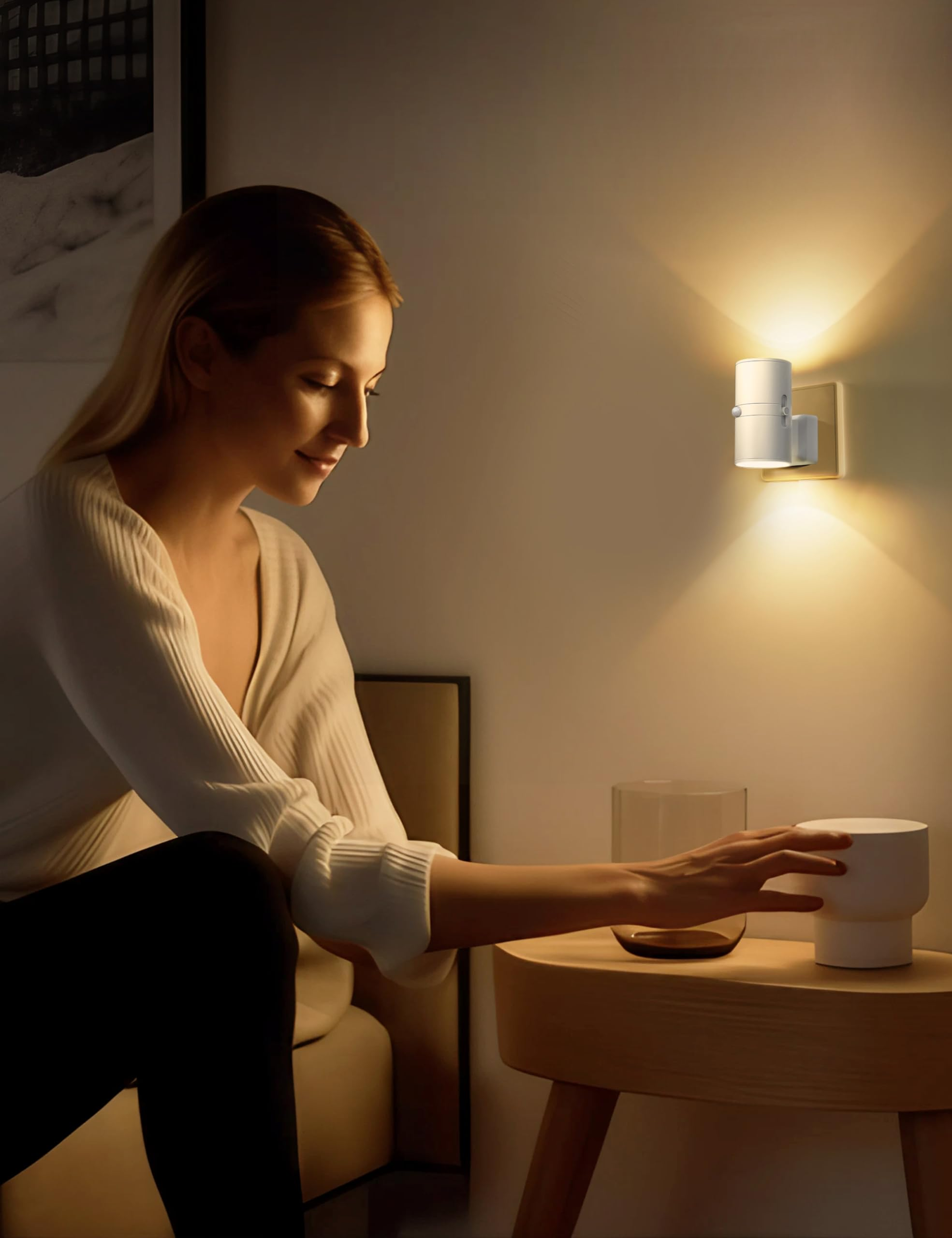 Frau greift nach einer weißen Lampe auf einem Holztisch. Über ihr scheint eine Wandlampe. Gedämpfte Beleuchtung.