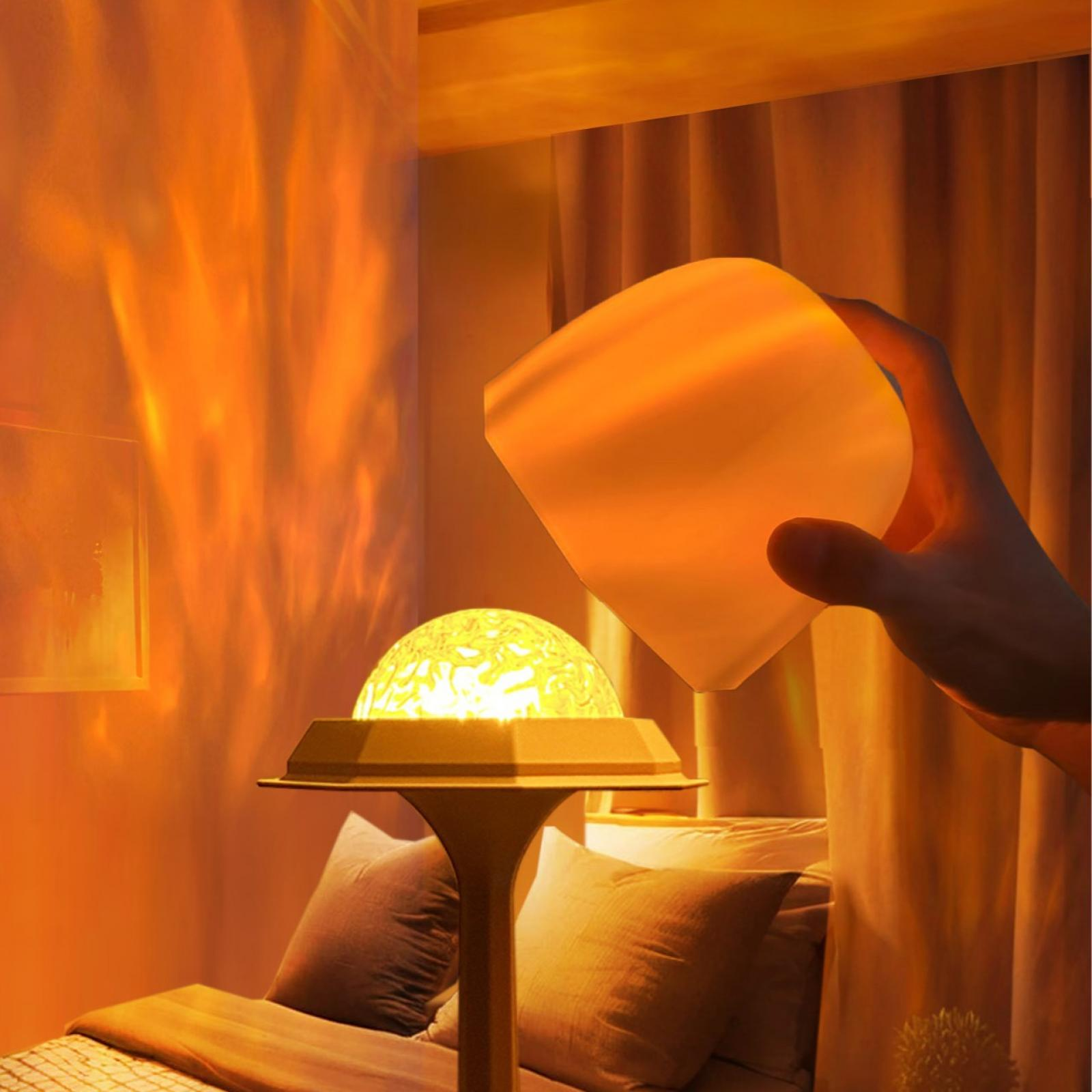 Eine Hand hält einen leuchtenden Würfel über einer Lampe. Die Lampe steht auf einem Bett. Warmes Licht füllt den Raum.