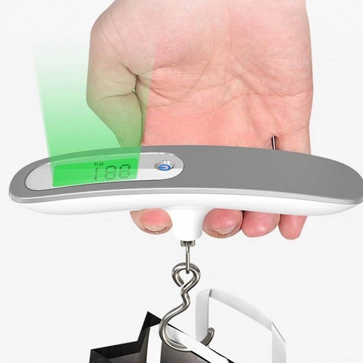 Eine Hand hält eine Gepäckwaage mit 1,88 kg. Die Waage ist grau und weiß, mit grünem Bildschirm und Metallhaken.