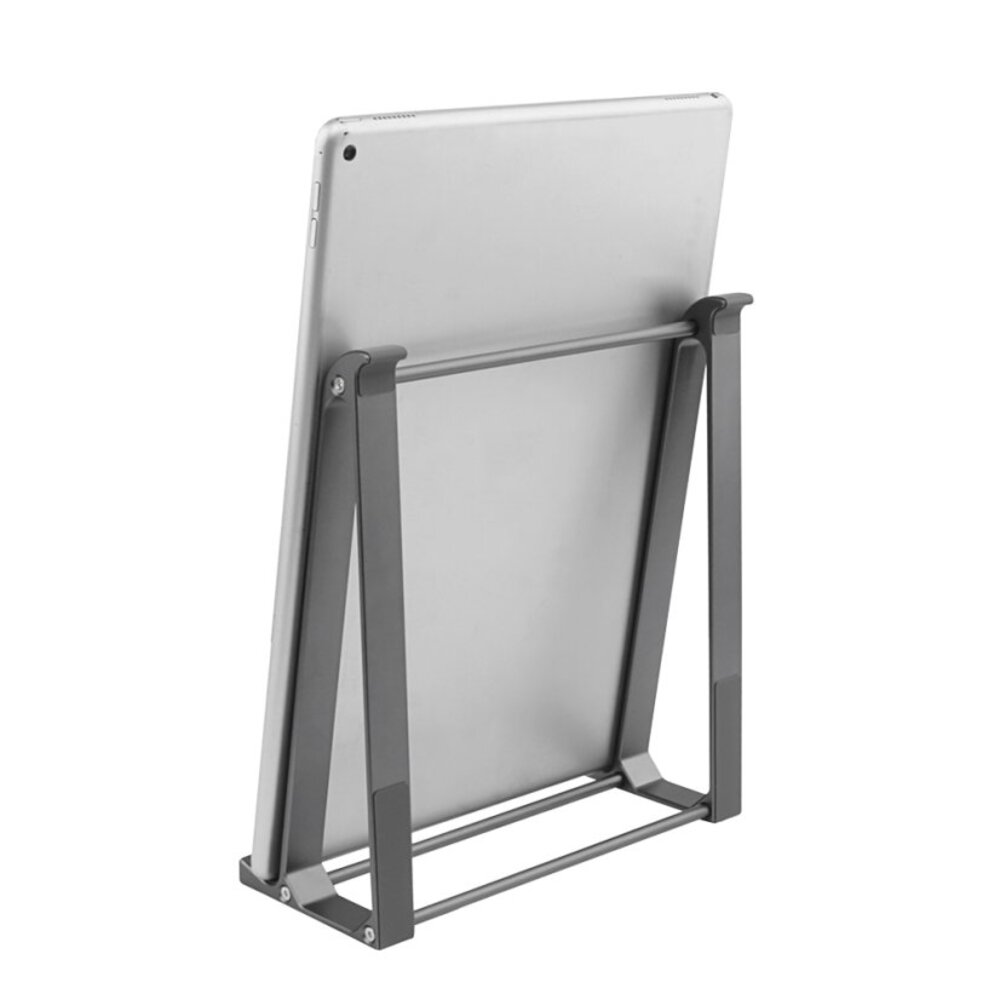 Srebrny tablet jest podparty szarym metalowym stojakiem na białym tle. Widoczny jest tył tabletu.