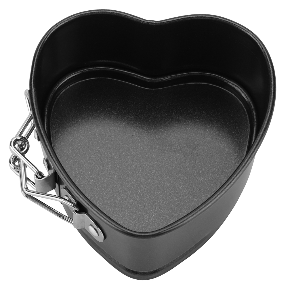 Eine herzförmige, schwarze Backform mit abnehmbarer Seite. Die Form ist leer und hat einen Metallverschluss an der Seite.