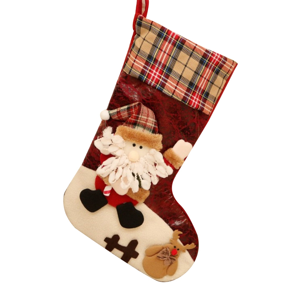 Ein Weihnachtsstrumpf mit Weihnachtsmann und Rentier. Der Strumpf ist rot mit kariertem Oberteil und weißer Basis.
