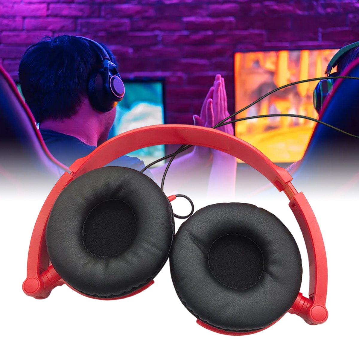 Rote Kopfhörer mit schwarzen Ohrmuscheln im Fokus. Gamer im Hintergrund, einer mit erhobenen Händen, zwei Bildschirme und eine lila Backsteinmauer.