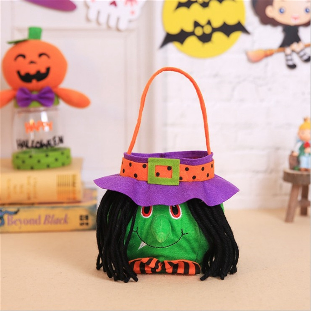 Eine Halloween-Hexentasche mit grünem Gesicht, schwarzem Haar und lila Hut. Im Hintergrund eine Kürbisdekoration und andere Halloween-Dekorationen.