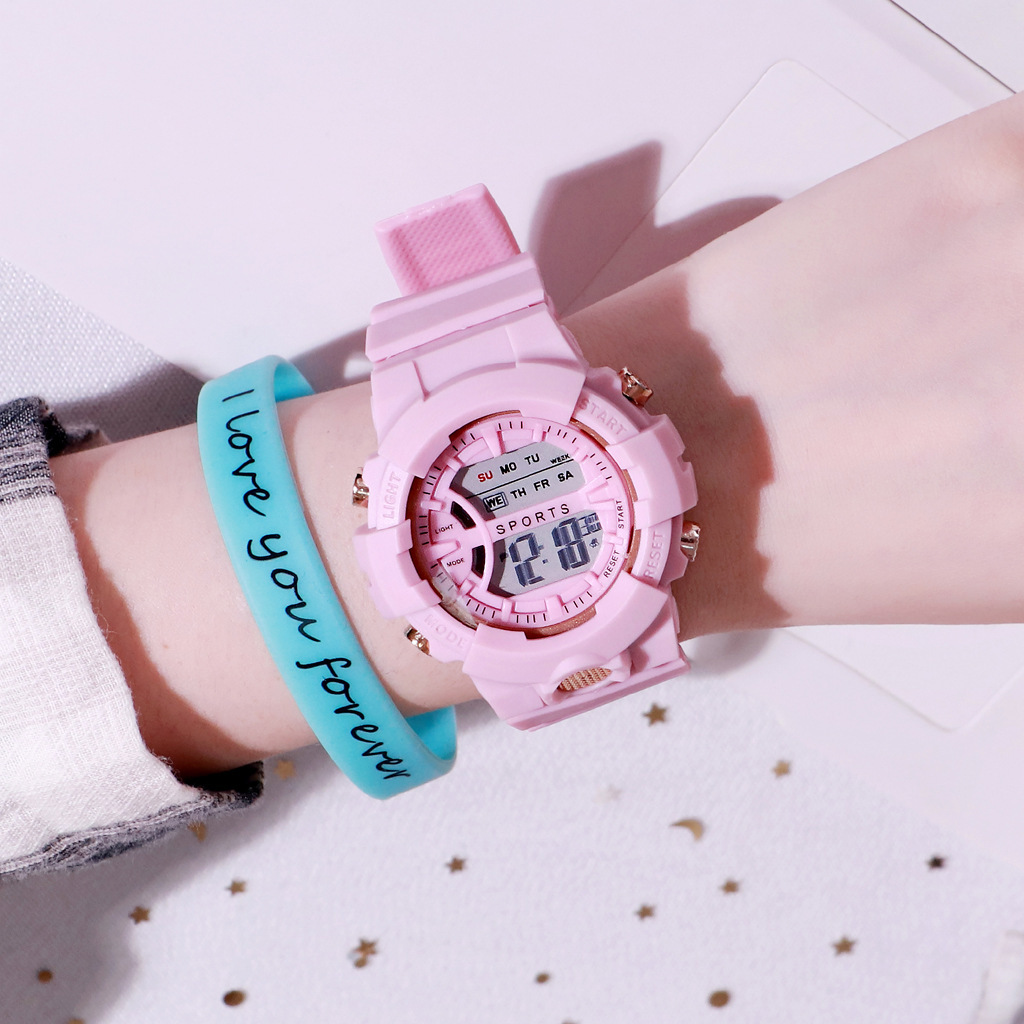 Eine rosa Sportuhr am Handgelenk, neben einem blauen Armband mit dem Text 'I love you forever'.