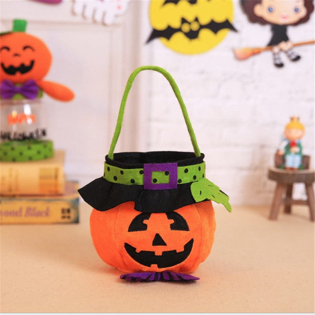 Eine orangefarbene, kürbisförmige Tasche mit schwarzem Hexenhut und grünem Griff. Auf der Vorderseite befindet sich ein lächelndes Gesicht. Halloween-Dekorationen im Hintergrund.