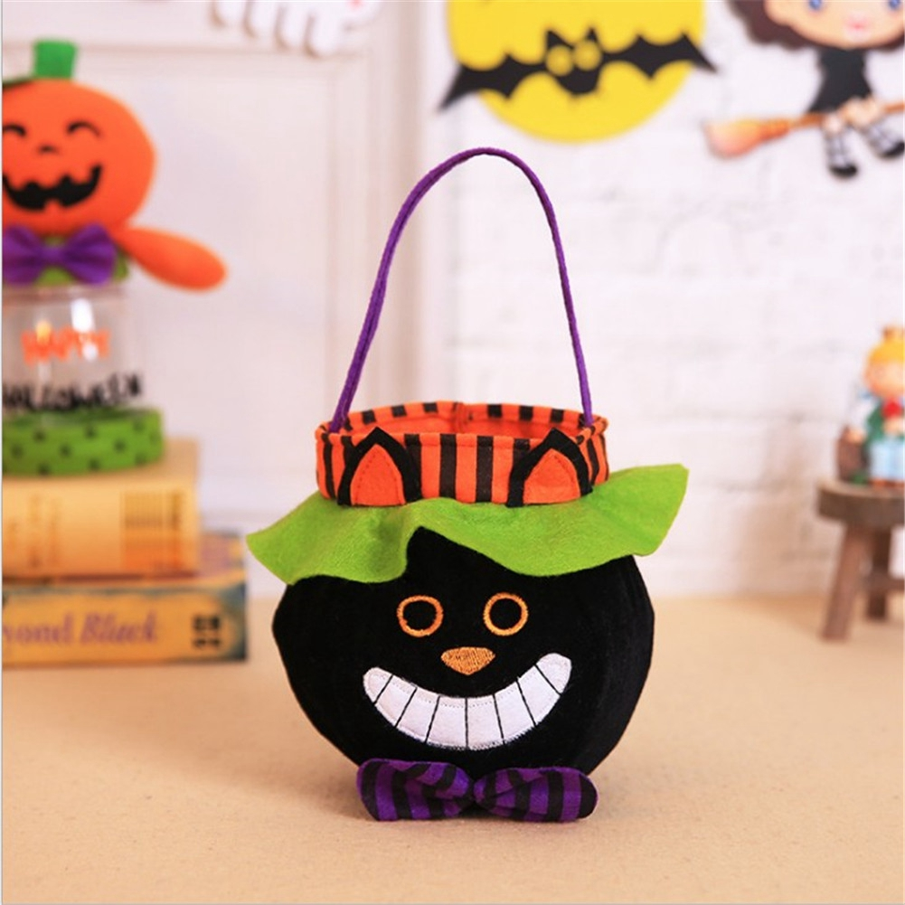 Eine schwarze Halloween-Süßigkeitentasche mit einem lächelnden Gesicht, einer lila Fliege und einem lila Griff. Orange und grüne Akzente sind vorhanden.