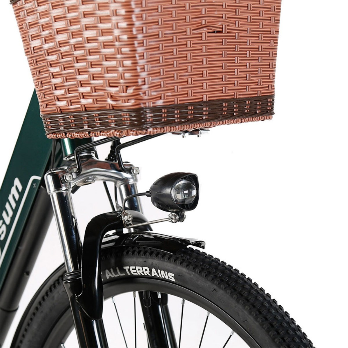 Przód roweru z brązowym wiklinowym koszem, czarną oponą i błotnikiem oraz reflektorem. Na oponie napis 'ALL TERRAINS'.