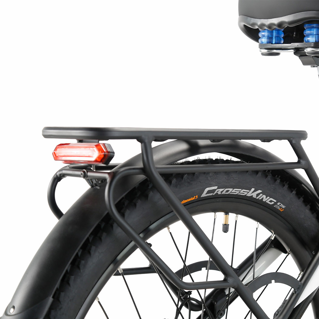 Tył czarnego roweru, opona CrossKing, tylne światło i bagażnik. Część siedzenia widoczna. Białe tło.