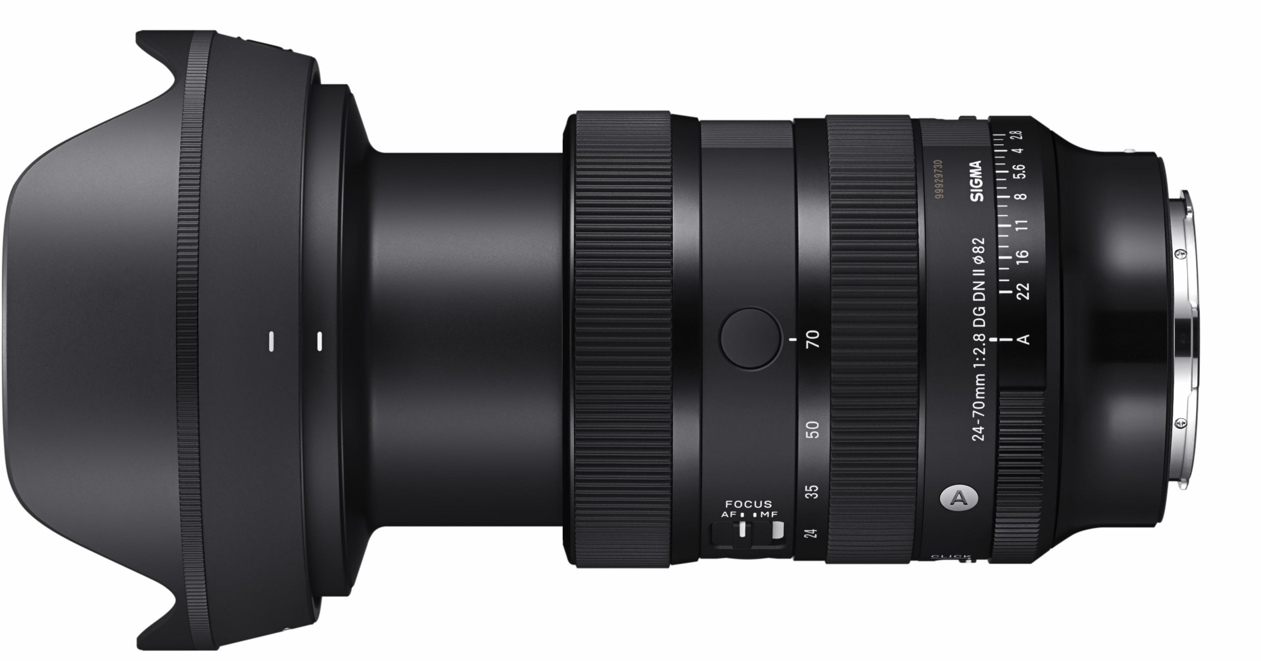 Czarny obiektyw Sigma 24-70mm leży poziomo. Posiada pierścienie ostrości, oznaczenia przysłony i logo Sigma.
