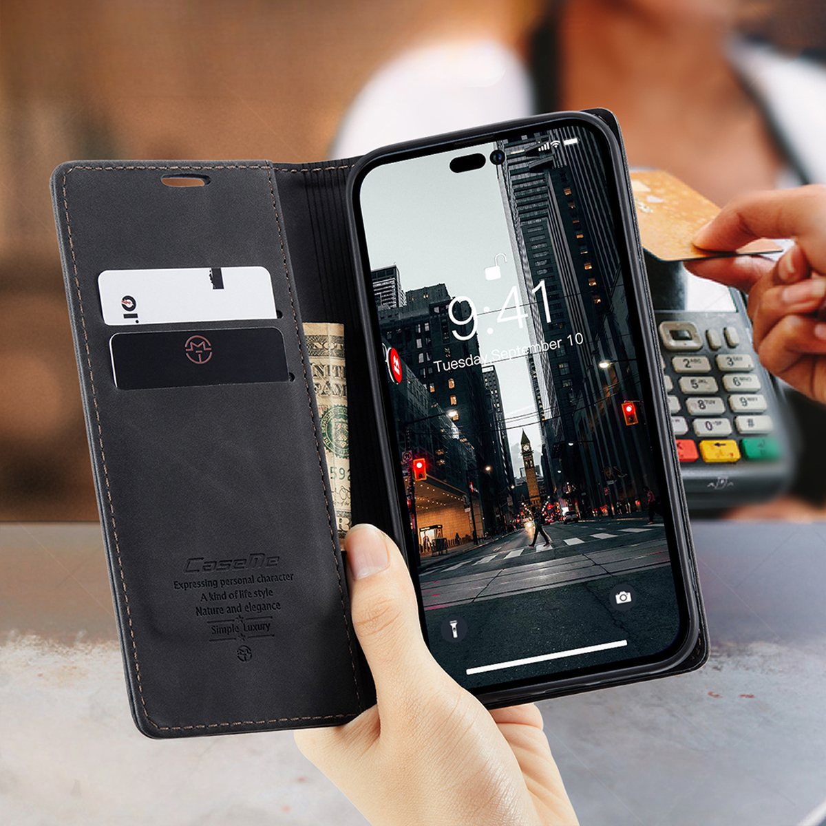 Eine Hand hält ein Telefon mit einer Stadtszene. Eine Brieftasche mit Karten und Bargeld ist geöffnet. Eine andere Hand benutzt ein Kartenlesegerät.