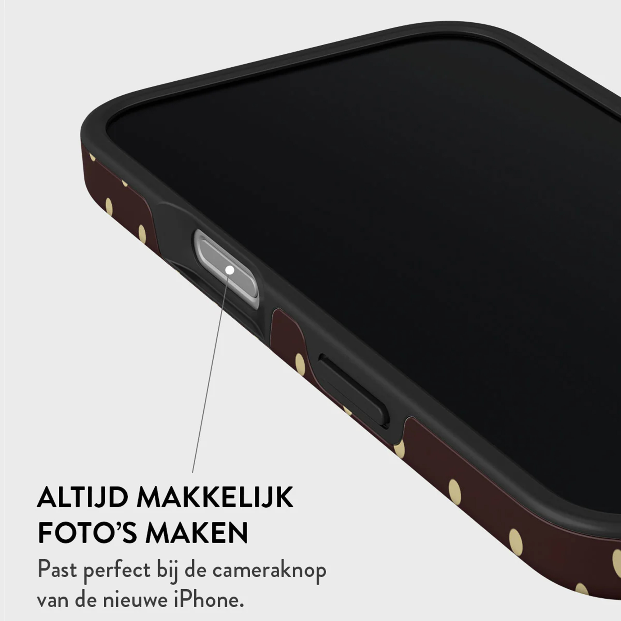 Gros plan d'un téléphone dans un étui à motifs. L'étui est marron avec des pois dorés.