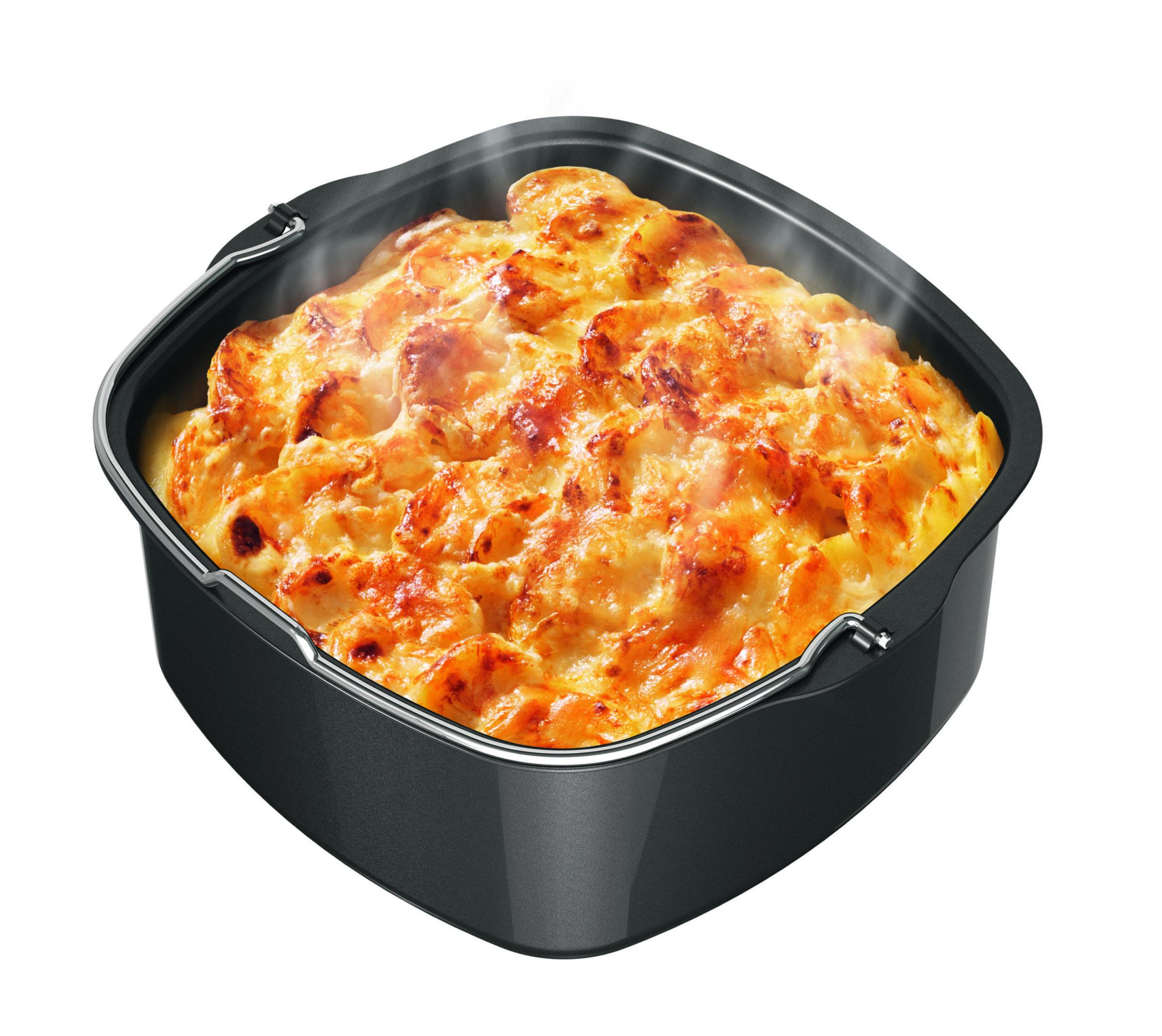 Un panier de friteuse à air carré et noir rempli d'aliments cuits au four. Les aliments sont dorés et de la vapeur s'en dégage.